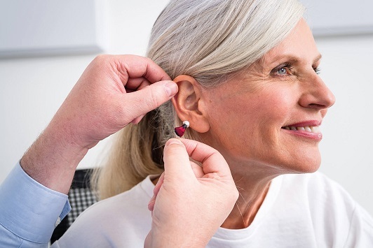 Seniorin erhält ein modernes Hörgerät zur Unterstützung bei Hörverlust vom Akustiker.